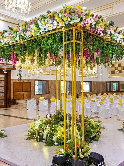 This modern wedding mandap is a perfect example of our contemporary designs. The open-air structure with lush greenery and hanging crystals creates a beautiful, light-filled space for your ceremony, blending elegance with a touch of nature.