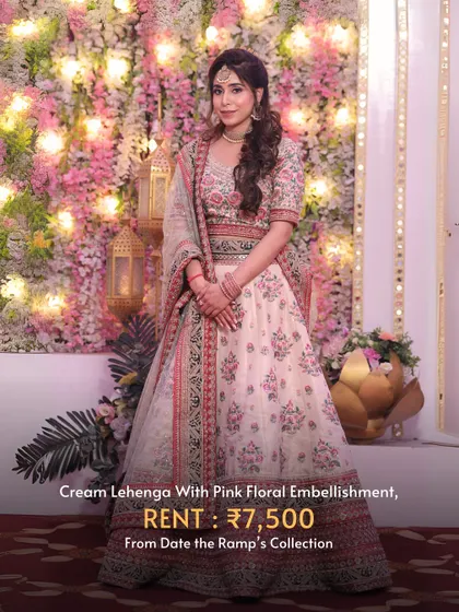 A cream lehenga with delicate pink floral embellishment, ideal for a sophisticated daytime event.