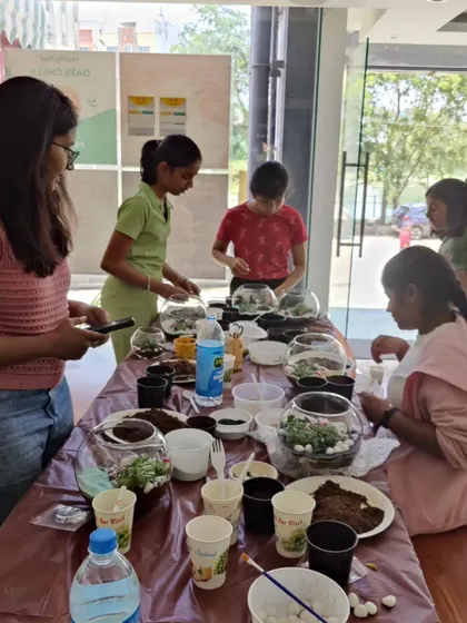A table full of young participants busy at work during a terrarium workshop. I provide all the supplies and guidance to ensure everyone has a great time.