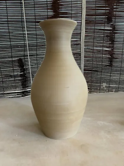 A collection of large, unglazed vases in various shapes and sizes. Each one is thrown on the wheel and showcases a different form, from classic curves to textured surfaces.