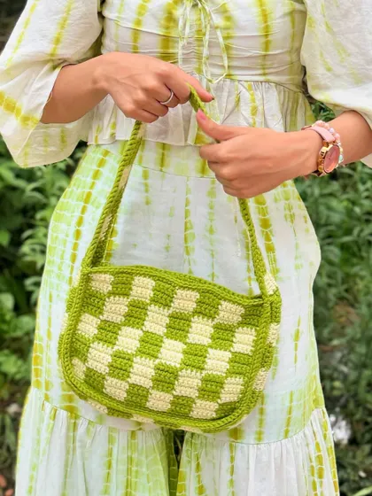 A closer look at the craftsmanship of our green and yellow crochet bag. It's the perfect summer accessory.