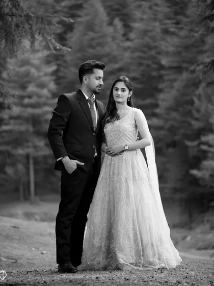 A classic black and white formal portrait, showcasing the timeless elegance of the couple and their attire.