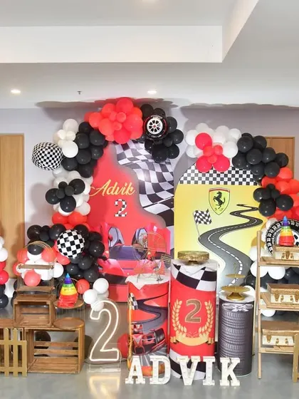 The full view of the race car party stage, with a light-up number '2' and themed props.