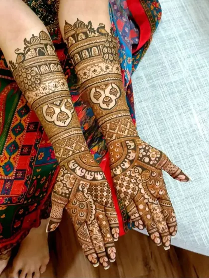 This design is packed with traditional elements, including jharokhas, peacocks, and auspicious symbols, perfect for a traditional bride.