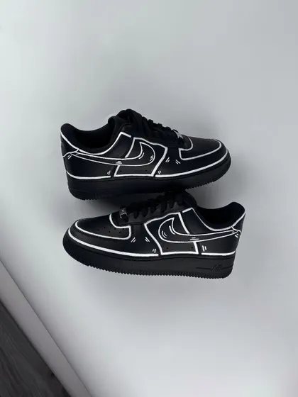 A top-down view of the black cartoon custom sneakers.