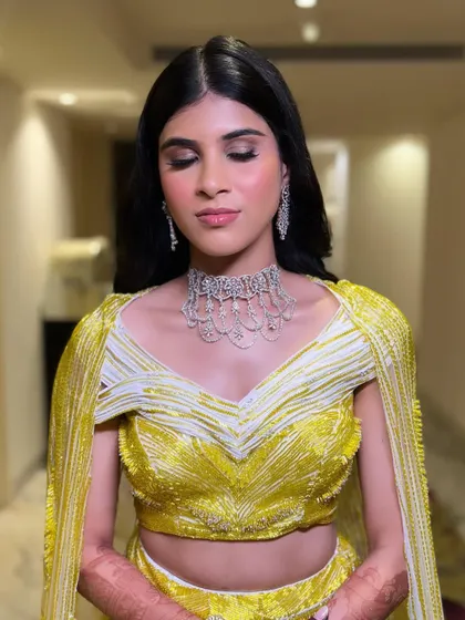Eyes closed to showcase the soft, shimmery eyeshadow. This sangeet makeup look is all about creating a dreamy and radiant effect.