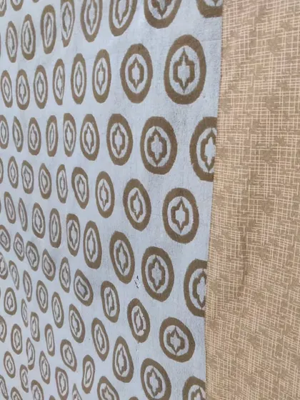 A close-up of an old tapestry restored into a quilt, showing the preserved pattern and new quilting.