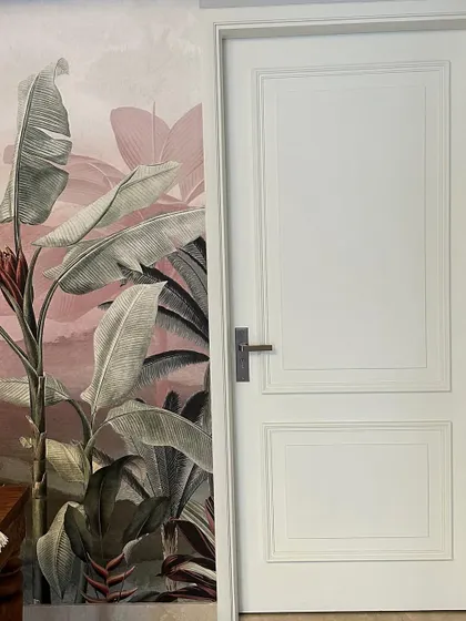 A full view of the white door and the stunning tropical wallpaper, showcasing a bold yet elegant design choice.
