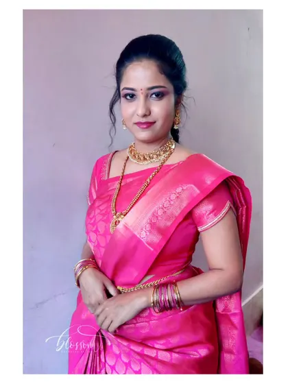 A portrait of the simple engagement look. The focus is on clean, fresh makeup that enhances her natural beauty, paired with traditional gold jewellery.