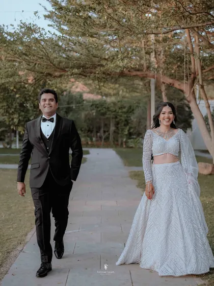 A happy, smiling shot of the couple walking together at their outdoor reception.
