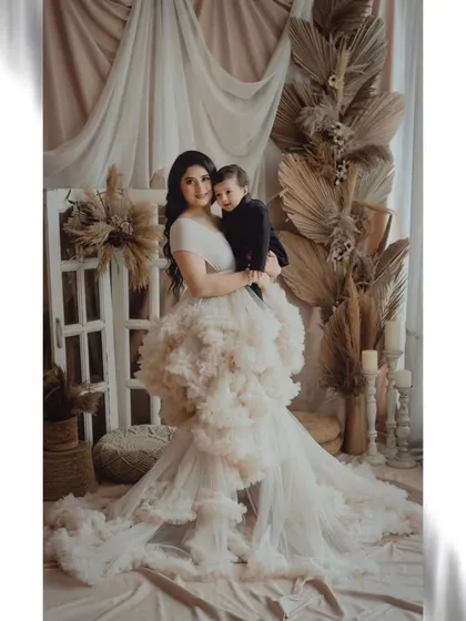 A full-length view of our stunning boho setup with a mother and child. The elaborate pampas grass and ruffled dress create a truly artistic and high-end portrait.