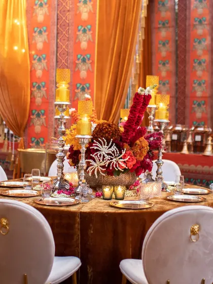Another angle of the ornate centerpiece, set against a backdrop of beautifully printed fabrics. The design is rich in cultural motifs and traditional craftsmanship.