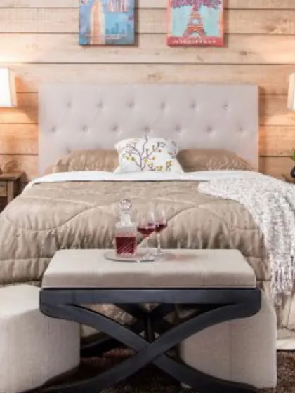 This bedroom setup shows how a padded bench and matching ottomans can add both function and a touch of luxury. Placed at the foot of the bed, this set provides extra seating and a convenient surface, all while complementing the room's cozy aesthetic.