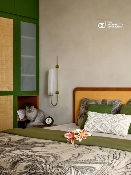 This bedroom from 'Cover me in Sunshine' features a beautiful green and rattan wardrobe. The family cat has found a cozy spot in the open niche, showing how our designs are loved by all family members.