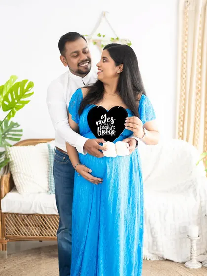 "Yes, it's a baby bump!" This couple uses a fun sign and tiny baby shoes to create a cute and memorable announcement photo.