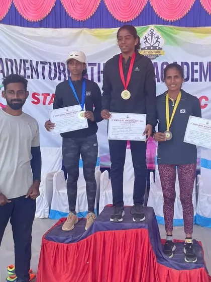 An athlete on the podium after winning bronze in the 400m at the Kanakapura State Athletic Meet.