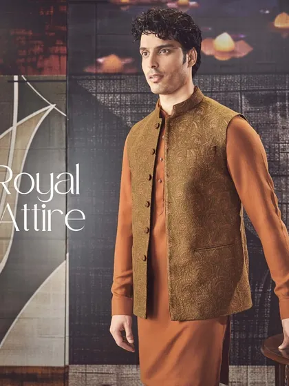 Royal attire for the modern man. This rust-colored kurta is paired with a textured brown bandi jacket, creating a warm and sophisticated look for any celebration.