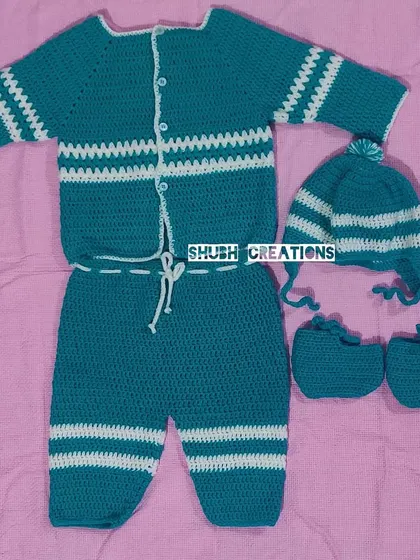 This complete hand-crocheted baby set, featuring a striped sweater, matching pants, a pom-pom hat, and tiny booties, is made with the softest yarn for your little one's comfort.