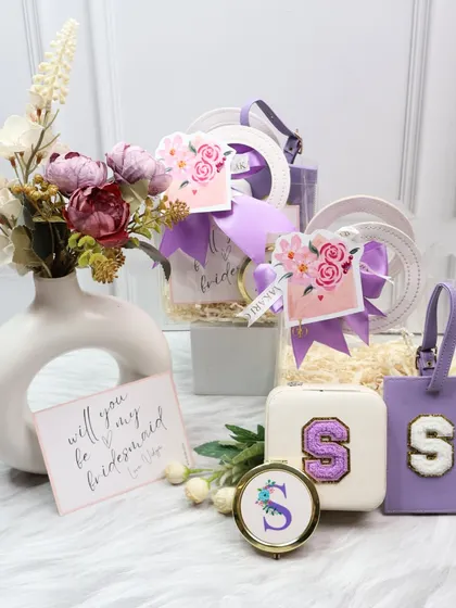 A beautiful lilac-themed bridesmaid proposal hamper. The set contains a personalized jewelry case, a matching luggage tag, and a custom pocket mirror, perfect for asking your best friends to stand by your side.
