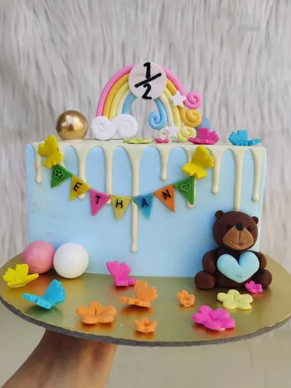 Another half-birthday cake, this one is rectangular and decorated with a cute teddy bear, rainbow, and drip effect.