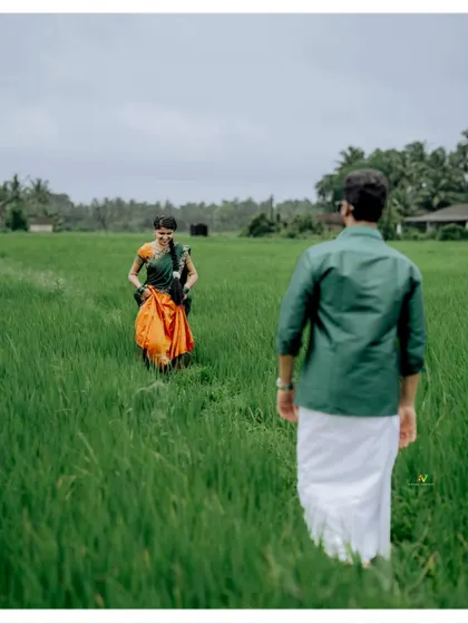 A playful chase through a lush green paddy field, capturing the joy and energy of the couple's love story.