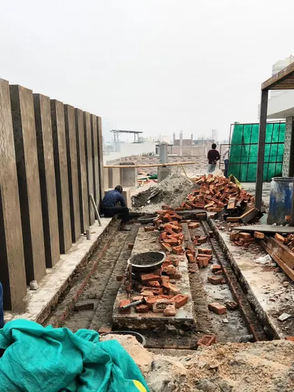 On-site work for a terrace water body. This image shows the detailed preparation and brickwork required for custom landscape features.