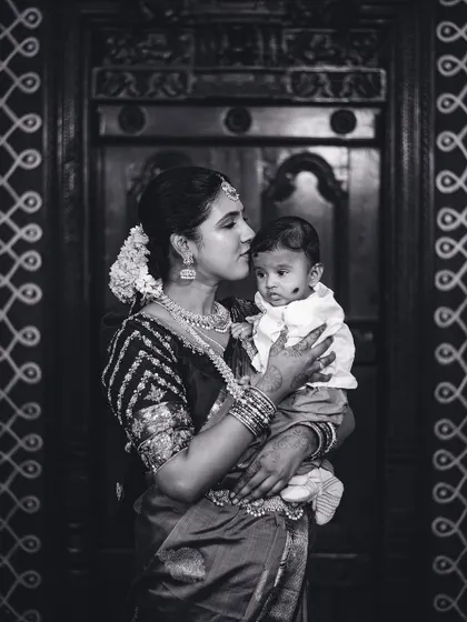 A tender black and white portrait of a mother kissing her baby's forehead. This classic style emphasizes the emotion and timelessness of the moment.