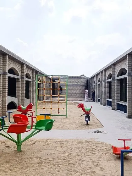 The sand-filled play area at Sai Kirupa Special School, surrounded by the arched corridors of the classrooms. The design provides a safe and stimulating outdoor environment for children.