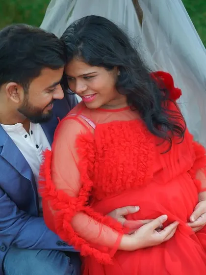 An intimate close-up from an outdoor maternity session. The couple shares a quiet moment, surrounded by nature, with the mother-to-be glowing in a vibrant red gown. These are the simple, heartfelt memories I love to capture.