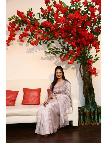 Our clean white sofa is a versatile prop that works with any theme. Here it's paired with a large red floral tree prop for a pop of color.