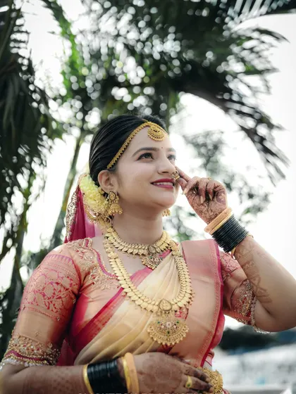 An upward-looking shot of the bride, capturing her hopeful expression and the intricate details of her makeup and jewelry.