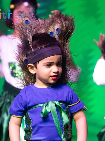 A child dressed as a peacock, an animal that dances in the rain, performs in the Bhumi (Earth) segment.