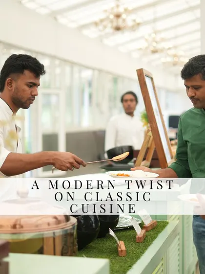 We offer a modern twist on classic cuisine. A guest is being served at our stylish buffet, which features traditional copper pots and a clean, contemporary setup.