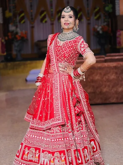 A full-length view of the bride in her stunning red lehenga with intricate elephant motifs. My course covers how to create a look that complements such detailed outfits.