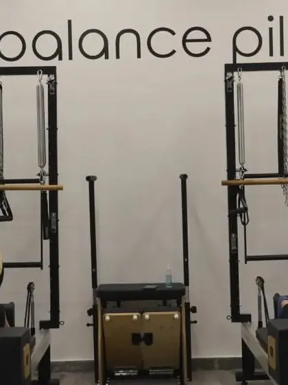 Two clients holding a strong plank on the reformer box, demonstrating core strength and endurance.