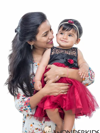 A mother and her toddler daughter share a look of pure love and affection. This simple studio portrait on a white background is timeless and full of emotion.