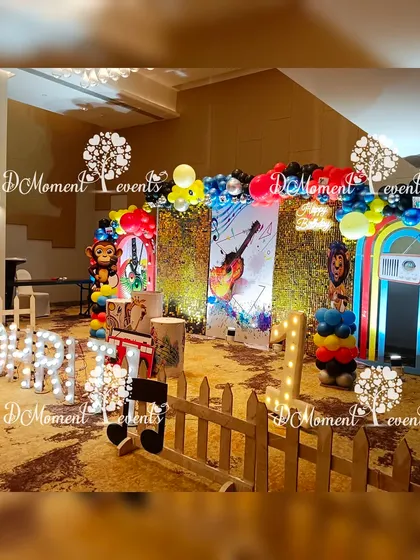 A wide shot of the music-themed party setup, showing the stage, white picket fence, and overall festive layout.