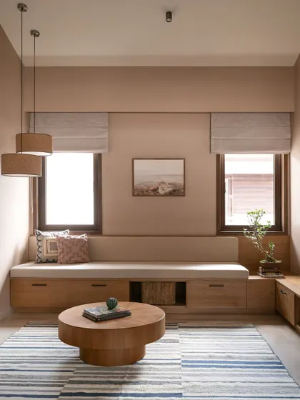 This cozy nook features a built-in bench with storage underneath, making it a perfect spot for reading. The dusty terracotta walls and striped rug add to the warm, earthy feel of the space.