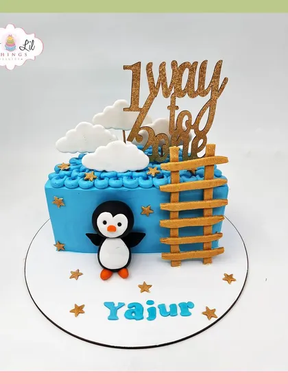 A sweet penguin-themed cake celebrating Yajur's journey "1 way to one," featuring a ladder to the sky.
