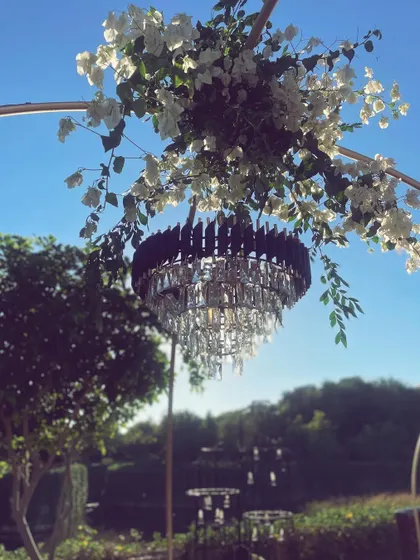 A detail of the sangeet decor, where we contrasted a modern crystal chandelier with soft, natural bougainvillea against a clear blue sky. This blend of glamour and nature is a signature of our design philosophy.