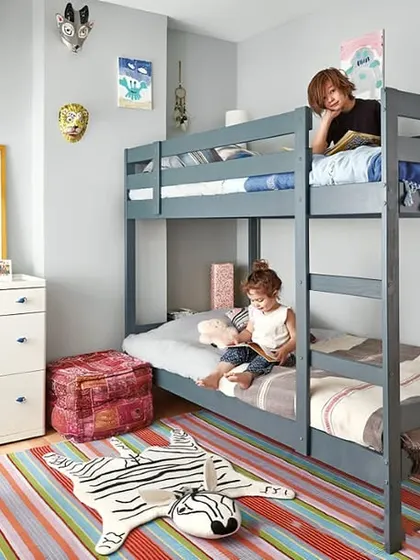 A simple grey bunk bed shown in a real kids' room, proving how practical and stylish they can be.