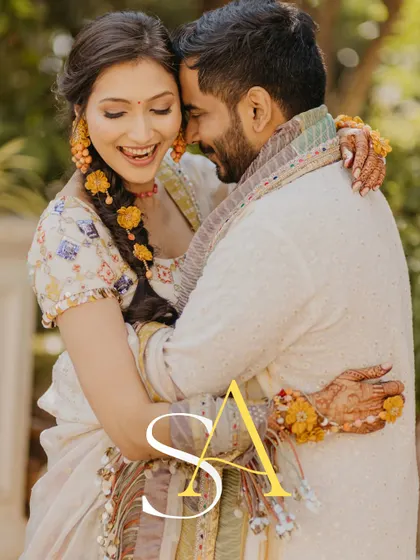 A joyful and intimate embrace between the couple. This close-up shot, with their initials overlaid, is a perfect capture of their love and happiness during the Haldi ceremony.