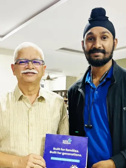 An elderly customer with our team member, holding our "Built for Generations" booklet. A testament to our commitment to long-term quality.