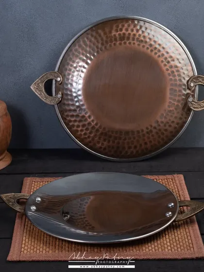 Photographing highly reflective surfaces like this steel and copper tawa is a technical challenge. I use specific lighting techniques to control reflections and showcase the product's finish without distracting glare.