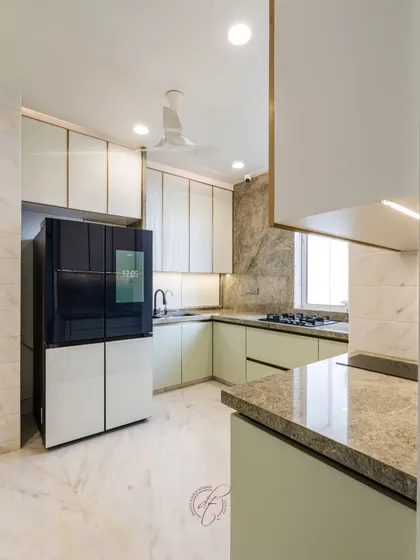 This wide shot showcases the L-shaped kitchen layout with its smart refrigerator and ample counter space. The under-cabinet lighting provides excellent task lighting while adding to the ambient glow.