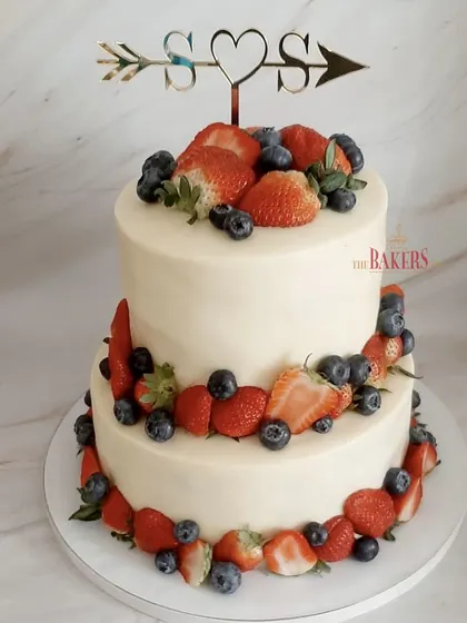 This super chic two-tier cake was perfect for a cocktail party. It’s a simple, elegant design featuring a vanilla and mixed berry cake with cream cheese frosting, adorned with fresh, juicy strawberries and blueberries.