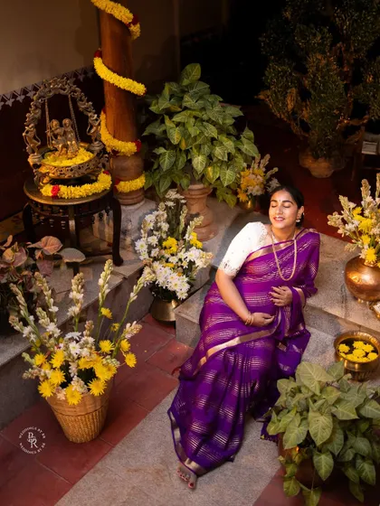 An overhead shot capturing the full scene of a traditional maternity photoshoot, with the mother-to-be relaxing in a beautifully arranged courtyard.
