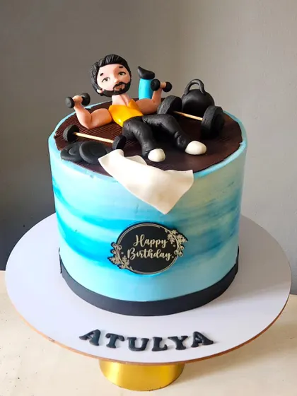 Perfect for a fitness enthusiast, this cake features a custom, hand-sculpted figurine working out. I included miniature dumbbells, kettlebells, and other gym equipment, all completely edible, to capture his passion for fitness.