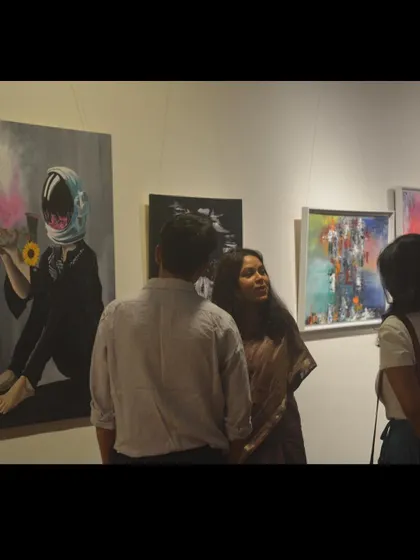 Explaining the concept behind one of my astronaut paintings to visitors at my gallery show. These conversations are a vital part of sharing the purpose and emotion behind my art.