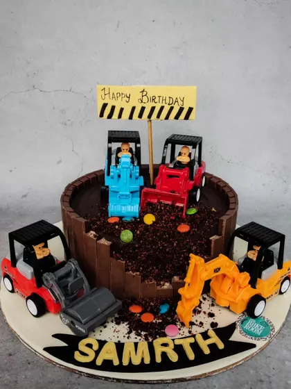 A fun construction-themed cake for Samrth's birthday. The cake is designed to look like a construction site, with chocolate "dirt" and toy trucks digging in.